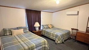 A hotel room with two beds, a chair, a dresser, and a lamp. - Poolside House #17 - Sleeps 14 (Kingsland)