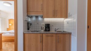 Una cocina pequeña con armarios de madera, una encimera y una cafetera.