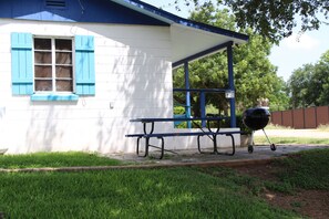 A house with a covered porch, a barbecue grill, and a picnic table. - Kingsland Pet Friendly Cabin Ideal for Weekly Stay (Kingsland)