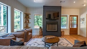 Un salón amplio con chimenea, ventanas grandes y una zona de estar acogedora.