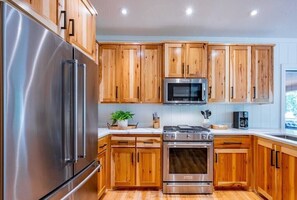 Enjoy cooking in this well-equipped kitchen with a refrigerator, oven, microwave, and ample countertop space.