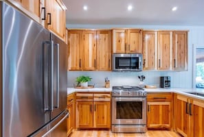 Enjoy cooking in this well-equipped kitchen with a refrigerator, oven, microwave, and ample countertop space.