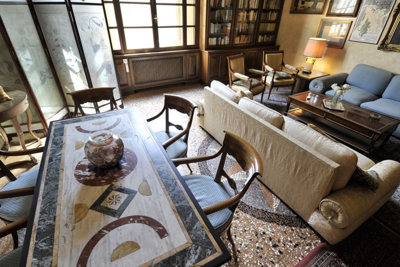 A cozy living room with a marble coffee table, a sofa, and a bookshelf filled with books.