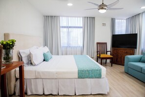 A hotel room with a bed, a TV, a sofa, and a ceiling fan. - Suites Coben (Tlalnepantla de Baz)