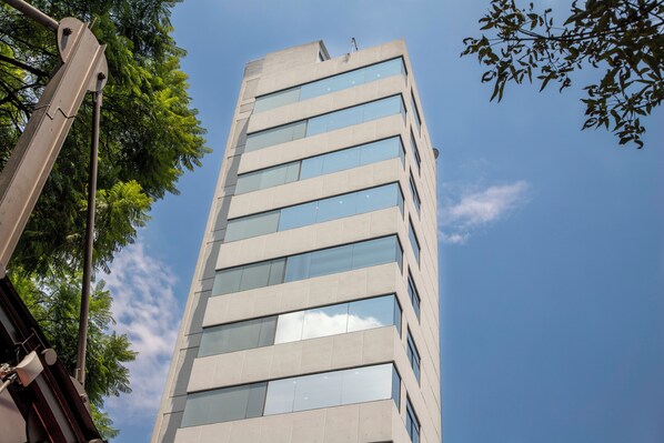 A tall, modern building with multiple windows and a clear sky. - Suites Coben (Tlalnepantla de Baz)
