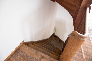 Una escalera de madera con diseño curvo, que sube a un piso superior.