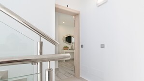 Ein modernes Interieur mit Glastrennwand, Holztür und weißer Wand mit der Zahl 3.
