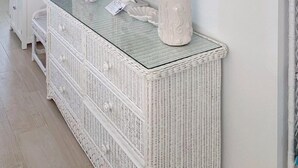 A white wicker console table with two lamps and a mirror. - Beachside Unit 09 - Key Colony (Key Colony Beach)