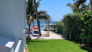 A well-maintained lawn with a wooden pergola and a view of the beach. - Beachside Unit 09 - Key Colony (Key Colony Beach)