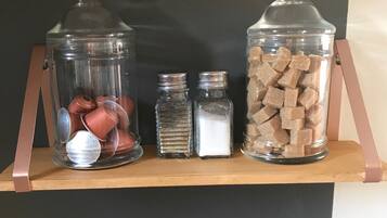 Une étagère sur laquelle reposent trois récipients en verre contenant divers objets.