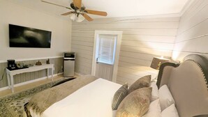 A bedroom with a bed, a desk, a television, and a ceiling fan. - Standard Guest Room (Main) - Barefoot Hills - North Georgia Mountains (Dahlonega)