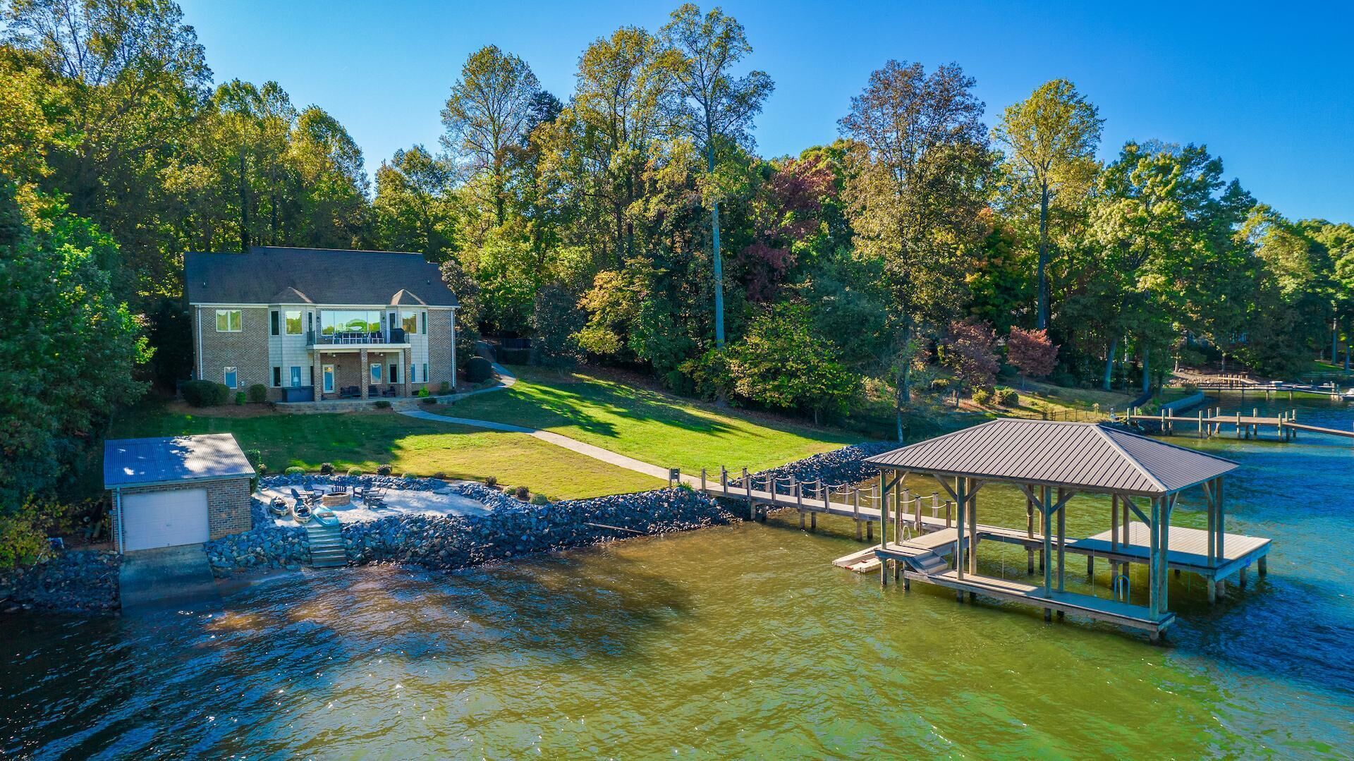 A large house with a dock and a gazebo by a lake.