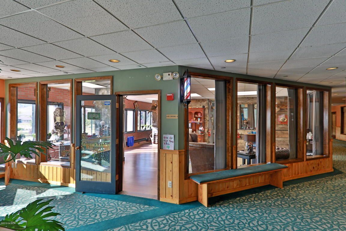 Un hall con un banco de madera, vitrinas de vidrio y un techo de azulejos.