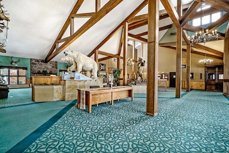 A spacious room with high ceilings, wooden beams, and a patterned carpet.