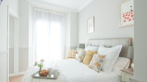 A neatly arranged bedroom with a bed, bedside tables, a tray with cups and a basket, and a window with curtains. - Stylish Apt PZA MAYOR / La Latina 2BD * 2BT *, 6p max (Madrid)