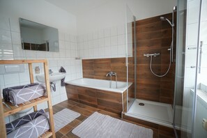 Ein modernes Badezimmer mit Dusche, Badewanne und Waschbecken.