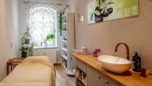 A bathroom with a wooden vanity, a large white basin, a mirror, and a shelf with toiletries. - Ferienwohnungen Familie Junge (Sehmatal)