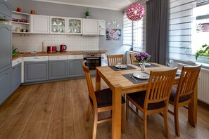 Una cocina moderna con armarios grises, una mesa de comedor de madera y un ventanal con vistas.