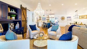 A spacious living room with a chandelier, two sofas, a coffee table, and a dining area in the background. - Summer Status (Mooresville)