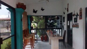 Une pièce spacieuse comprenant un coin repas, un ventilateur de plafond et une grande fenêtre donnant sur l’extérieur.