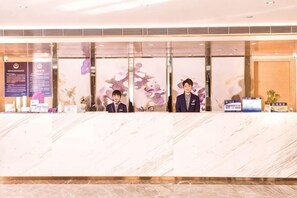A reception desk with a marble counter, glass partitions, and a sign with information. - Lavande Hotel (Beijing Changping Stadium) (Changping)