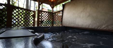 Un bain à remous doté d’une structure en bois et de panneaux ajourés.