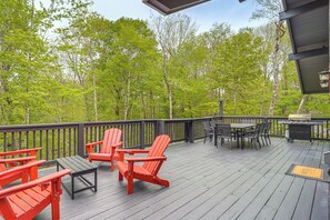 A deck with Adirondack chairs, a table, and a grill. - 'Bear Crossing Chalet:' Beech Mountain Family Home (Beech Mountain)