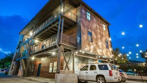 A multi-story building with a modern design, featuring a staircase on the left side and a balcony on the upper floor. - Bishop Arts Hotel Penthouse Suite 7 (Dallas)