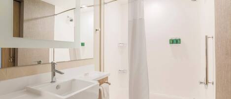 Un baño moderno con un espejo grande, dos lavamanos, una ducha y una bañera.