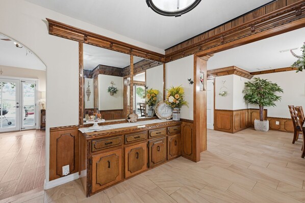 A bathroom with wooden cabinetry, a large mirror, and a potted plant. - Prestige Mountain View with a relaxing Waterfront at Arkansas River. (Howard)