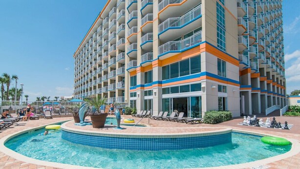 A hotel with a pool area, including a circular pool and lounge chairs. - 3 bedroom 2 Bath, Unit 521, Unobstructed Ocean View, water park (Myrtle Beach)