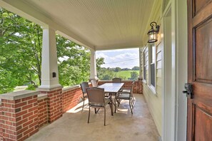 Enjoy a peaceful outdoor space with a table and chairs, surrounded by lush greenery and a scenic view.