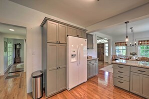 Enjoy cooking in this well-equipped kitchen with a central island, sink, and ample counter space.