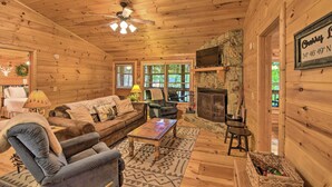 A cozy cabin interior with a wooden ceiling, a fireplace, a television, and a comfortable seating area. - 'Pinot & Pine' Chic Log Cabin ~ 5 Mi to Blue Ridge (Blue Ridge)
