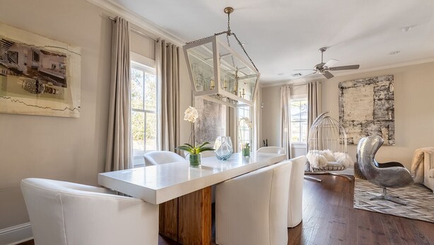 A modern dining area with a long table, white chairs, and a wooden cabinet. - Explore Magazine Street from a Chic, Tranquil Home (New Orleans)