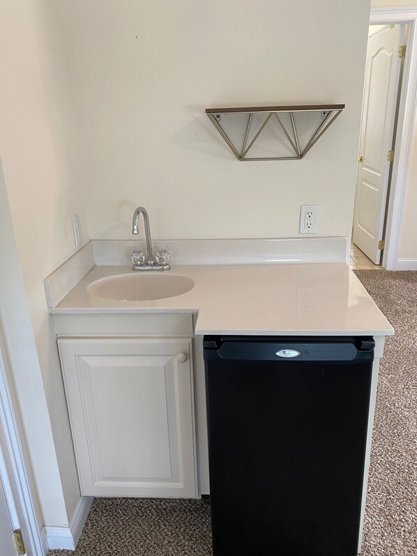 A compact kitchen with a sink, a dishwasher, and a wall-mounted shelf. - 7 minute walk to beach, sleeps 12, great for families! (Brigantine)