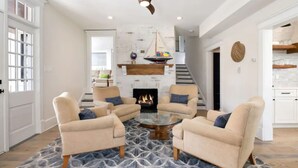 A spacious living room with a fireplace, comfortable seating, and a modern ceiling fan. - Just redone, 1 1/2 block from Ventnor beach (Ventnor City)