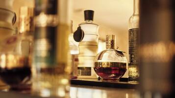 A variety of bottles on a reflective surface, likely a bar or kitchen counter.