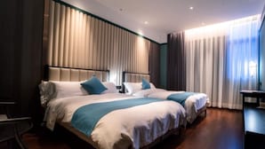 Habitación de hotel con dos camas, un escritorio y una silla.