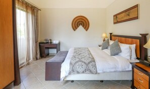 Ein Schlafzimmer mit einem Bett, Nachttischen, einem Schreibtisch und einem Stuhl.