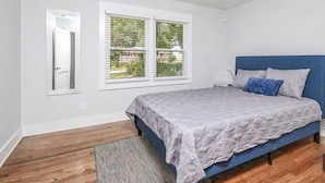 A bedroom with a bed, a window, and a door. - Cool City Cottage (MINS FROM AIRPORT/CITY) 2B 1B (Stone Mountain)