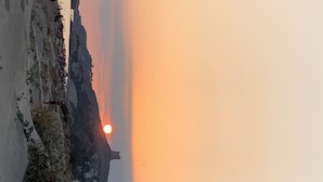 Un atardecer sobre un pueblo costero con edificios a lo largo de la orilla.