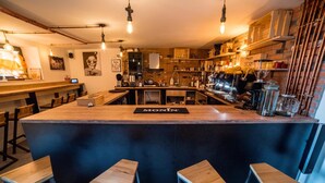 A modern bar area with a central island, bar stools, and various bar equipment.