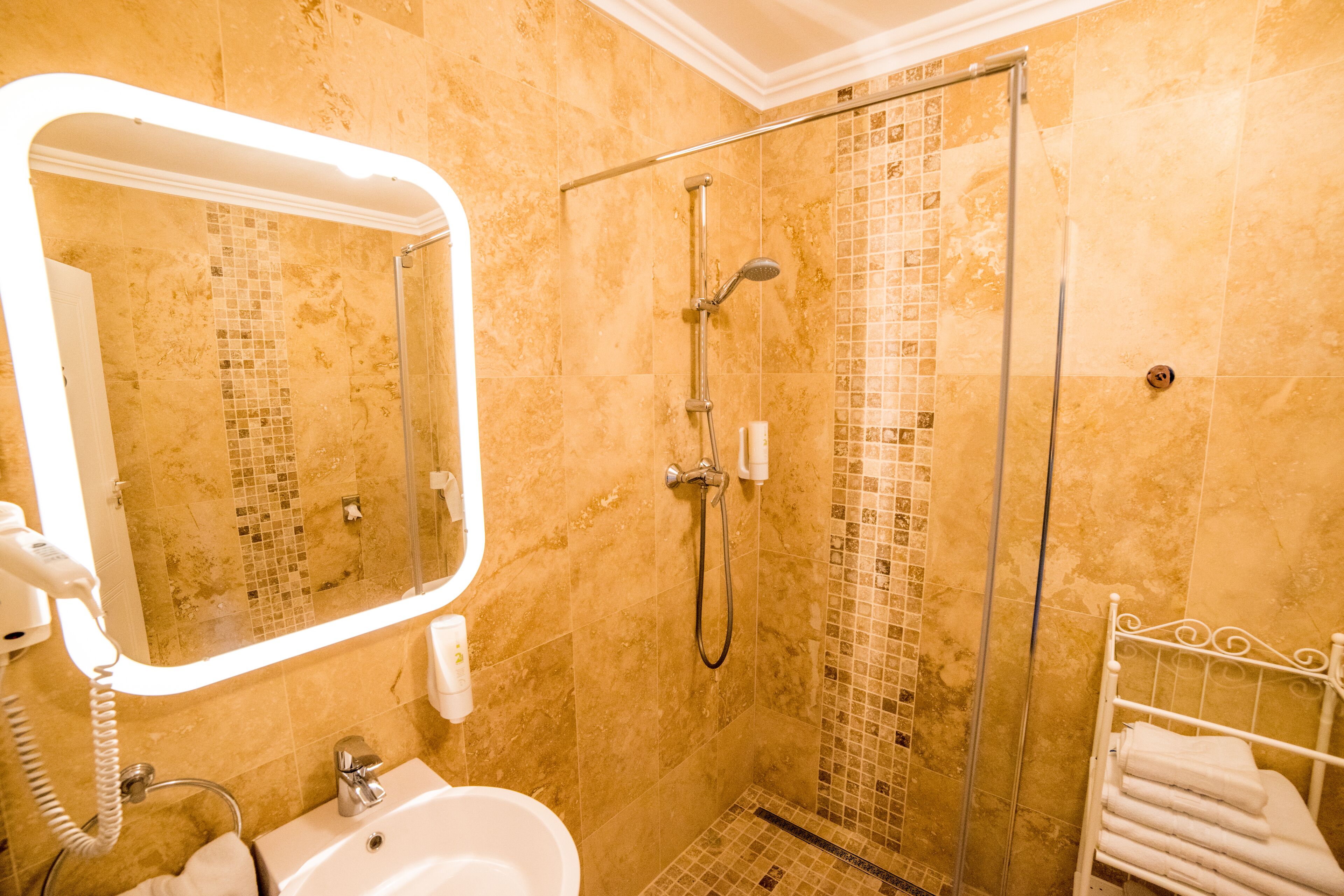 Un baño con ducha de vidrio, lavamanos y espejo.