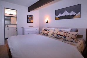 Cozy retreat with a neatly made bed, dresser, and nightstand, perfect for a restful stay.