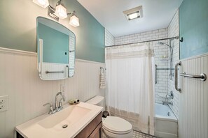 Une salle de bain avec un lavabo blanc, des toilettes, une baignoire et un espace douche.