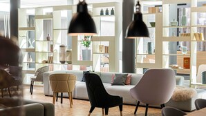 A modern living room with a sofa, chairs, and a bookshelf filled with decorative items. - Superior Plus - Saline 1822, Hotel Bad Rappenau (Bad Rappenau)
