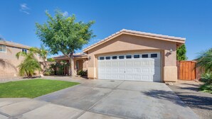 A residential house with a garage, a well-maintained lawn, and a clear blue sky. - Outdoor Oasis: Coachella Valley Group Getaway! (Coachella)