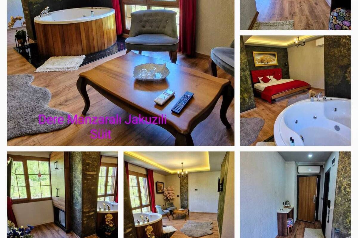 A room with a wooden floor, a large wooden table, a chair, a bathtub, and a window with red curtains.