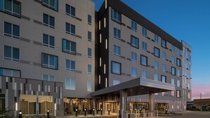 A modern hotel with a flat facade, multiple windows, and a covered entrance area. - Courtyard by Marriott Houston I-10 West/Memorial (Houston)